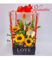 Caja con tulipanes y girasoles con flores y chocolate